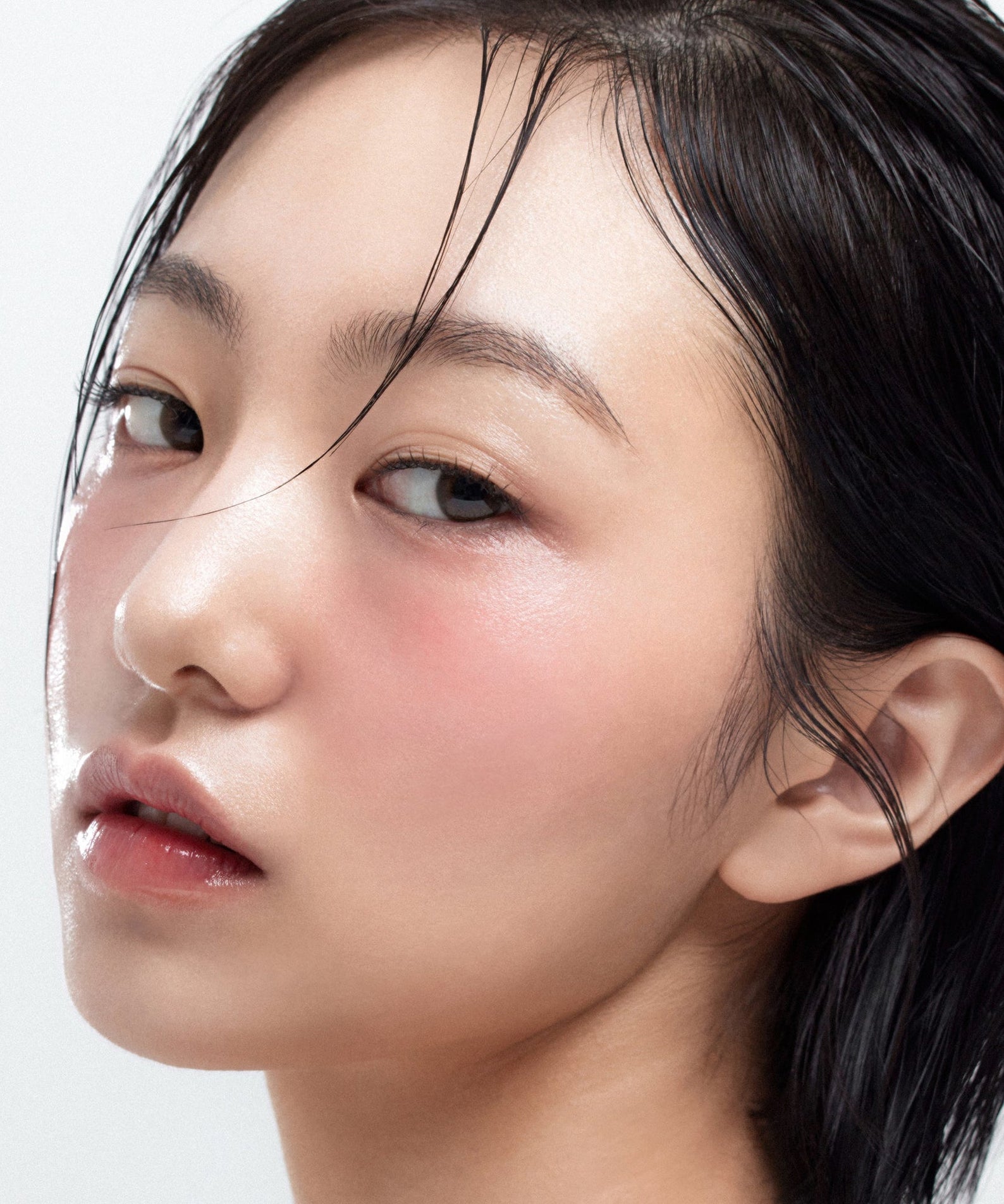 HOUSE OF HUR Moist Ampoule Blusher 10ml, en flacon, appliqué sur le visage d’une femme, fond clair studio