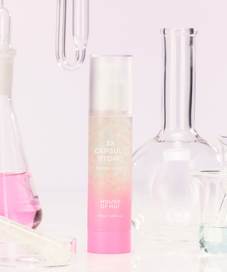 HOUSE OF HUR 3X Capsule Hydro Booster Cream 50ml devant des fioles de laboratoire, crème hydratante en bouteille de 50ml.