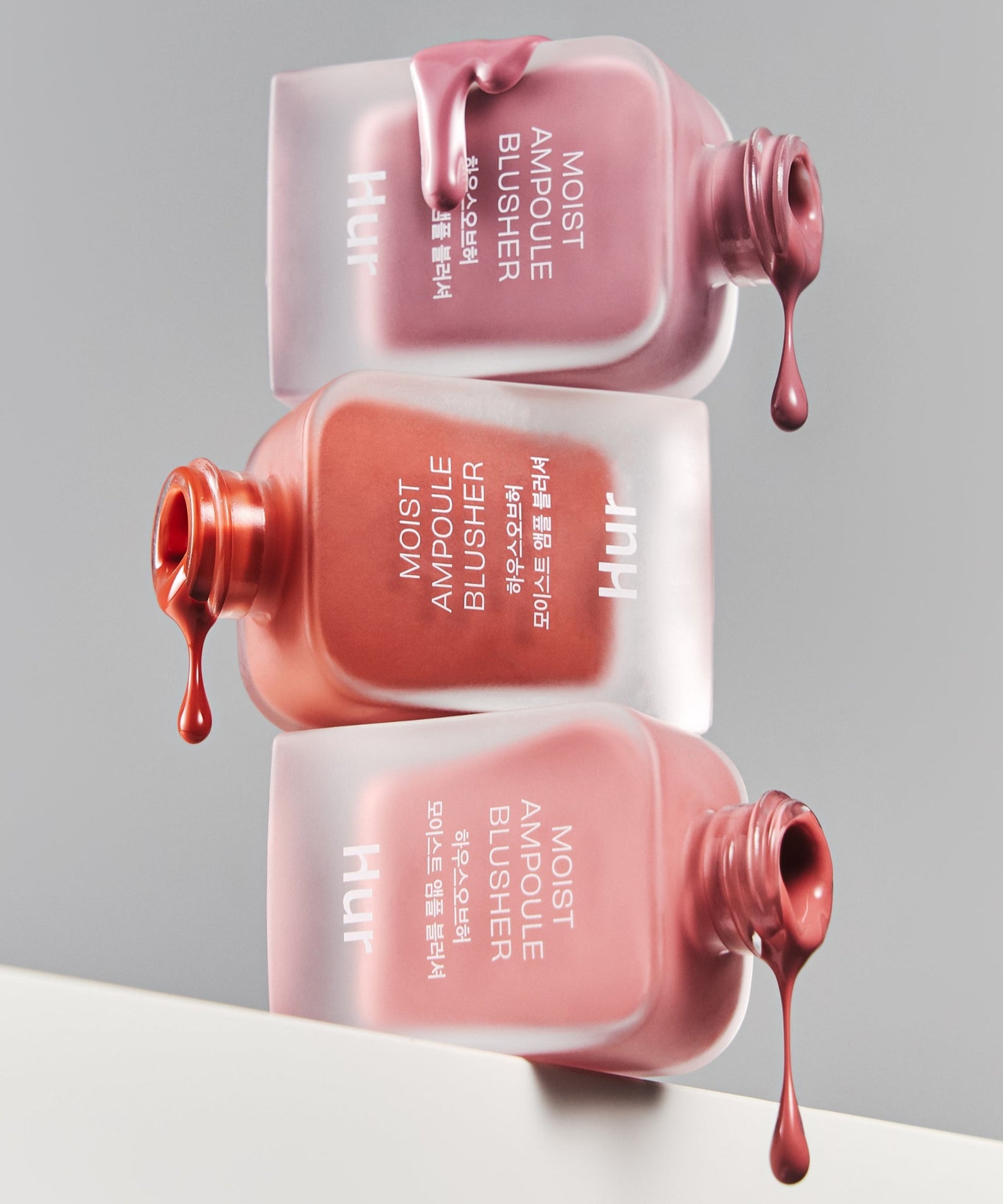 Flacons de HOUSE OF HUR Moist Ampoule Blusher 10ml, montrant des couleurs riches et une texture crémeuse pour un éclat naturel.