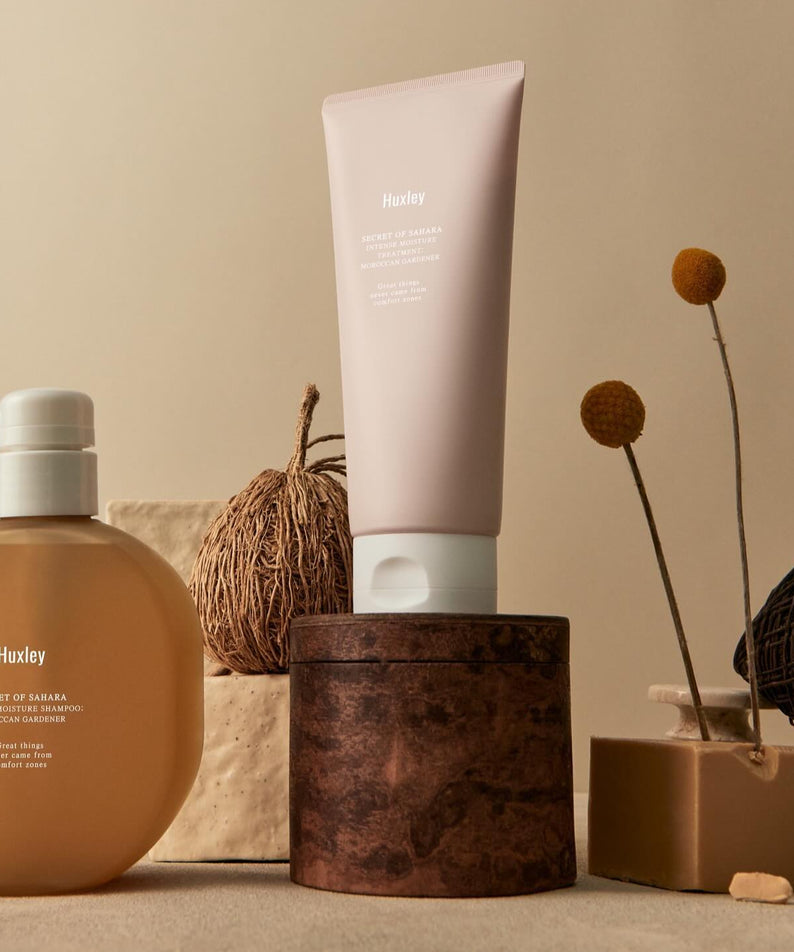 Produits de soin HUXLEY Intense Moisture Treatment Moroccan Gardener exposés sur une étagère élégante avec décor minimal.