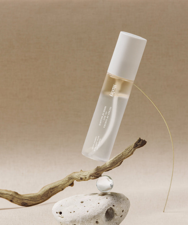 Flacon de HUXLEY Oil Mist Sense Of Balance sur un support naturel élégant. Parfait pour équilibrer et revitaliser la peau avec style.