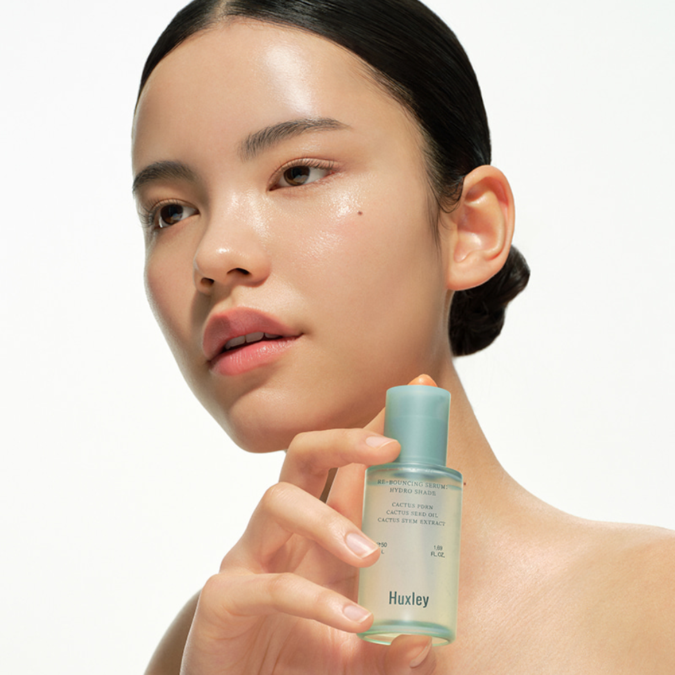 HUXLEY Rebouncing Serum Hydro Shade 50ml, sérum hydratant visage sur femme tenant le flacon, esthétique skincare.