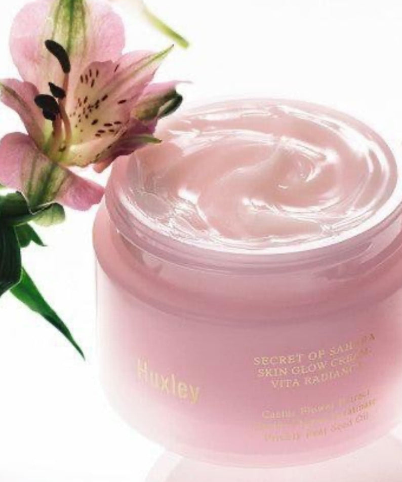 Crème HUXLEY Skin Glow Cream Vita Radiance hydratante avec fleur, pour une peau lumineuse en bouteille rose.