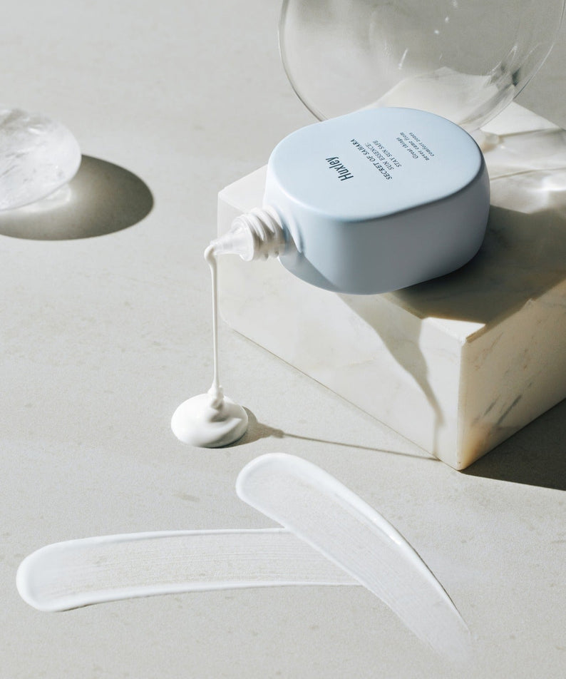 HUXLEY Sun Essence Stay Sun Safe sur une surface en marbre, montrant la texture du produit solaire, idéal pour une protection quotidienne.