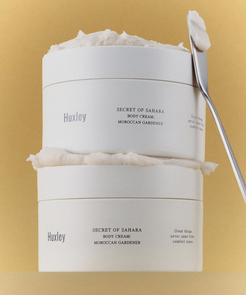 Crème pour le corps HUXLEY Moroccan Gardener Body Cream 200ml avec texture riche, hydratation intense, fond jaune, spatule argentée.