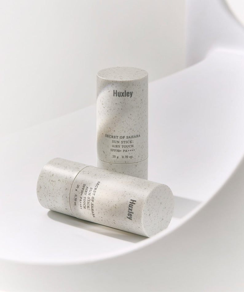 Produit cosmétique HUXLEY Sun Stick Airy Touch 20g sur fond blanc élégant, protection solaire portable et pratique.