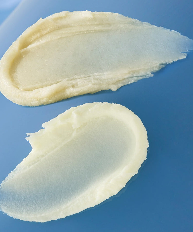 Texture du HUXLEY Sun Stick Airy Touch 20g, formant une finition lisse sur une surface bleue, idéale pour la protection solaire quotidienne.