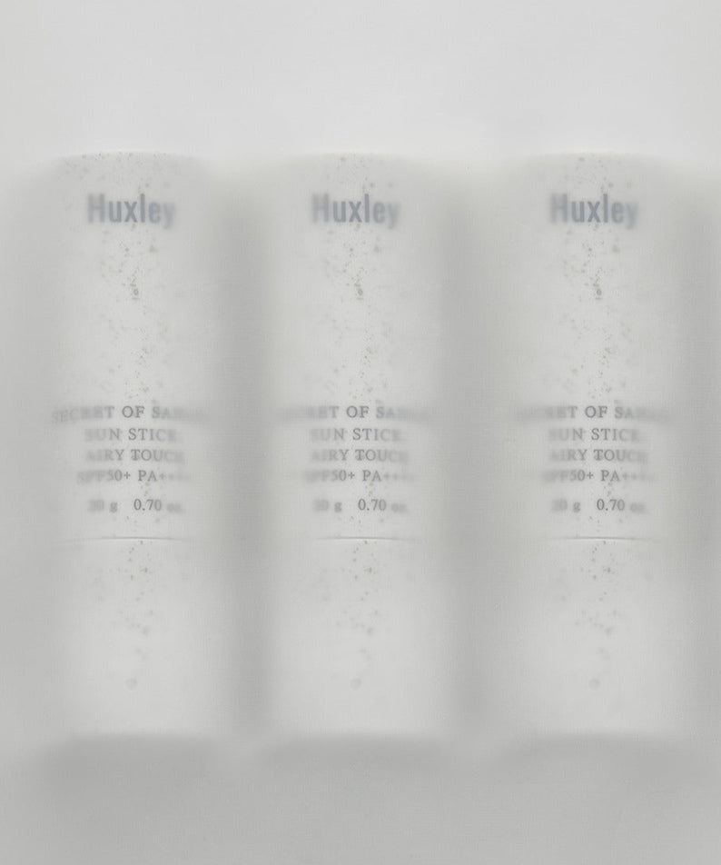Image de trois bâtons HUXLEY Sun Stick Airy Touch 20g, soin solaire en stick léger et rafraîchissant pour la peau.