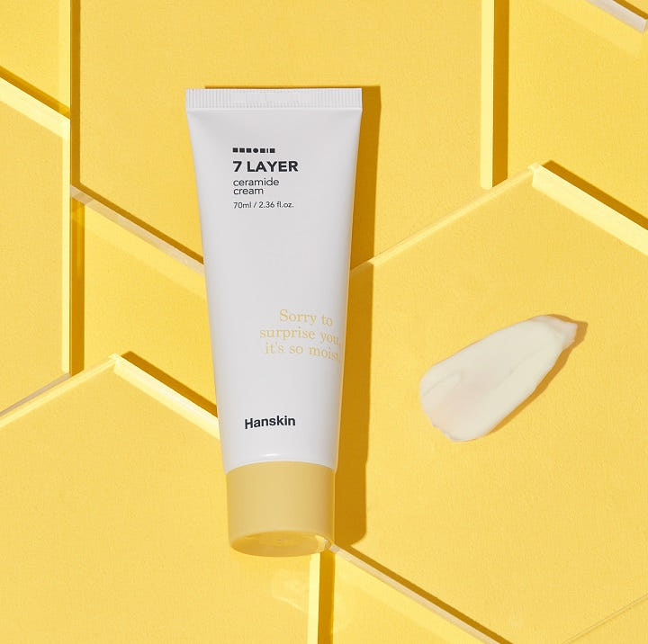 Hanskin Seven Layer Ceramide Cream 70ml, tube blanc sur fond jaune géométrique, style cosmétique de marque Hanskin.