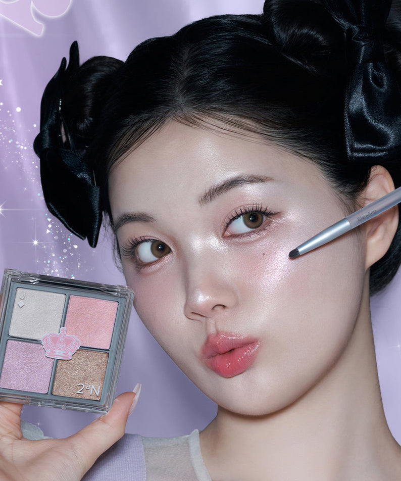 Femme appliquant le 2AN Jelly Glow Highlighter Palette 10.8g sur sa joue avec un pinceau, devant un arrière-plan violet brillant.