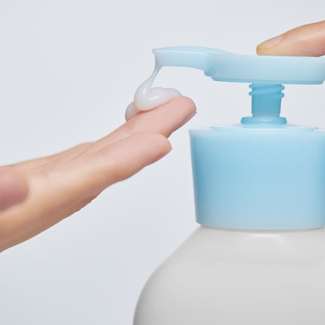 ILLIYOON Ceramide Ato 5.0 Gentle Skin Cleanser 400ml : main pressant une pompe, mousse, ambiance salle de bain.