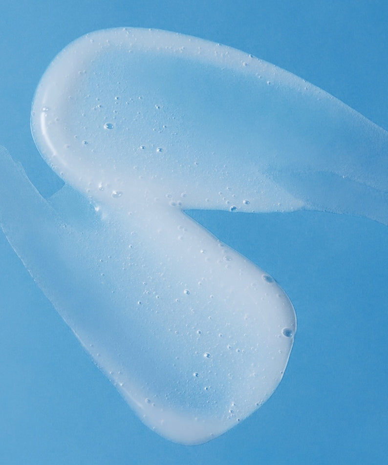 Texture du nettoyant doux pour la peau ILLIYOON Ceramide Ato 5.0 Gentle Skin Cleanser 400ml sur fond bleu.