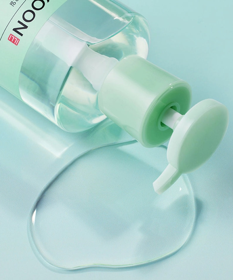 Flacon de 250ml d'ILLIYOON Gentle Deep Cleansing Oil avec pompe ouverte et huile renversée sur fond turquoise.