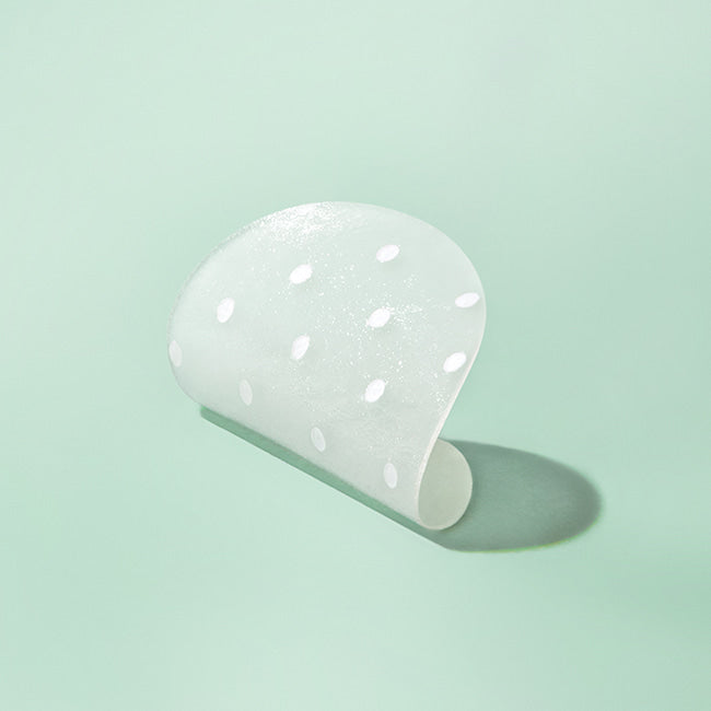 ILSO No Trouble Spot Patch, patch transparent sur fond vert, marque ILSO, avec motif de gouttes blanches visibles.