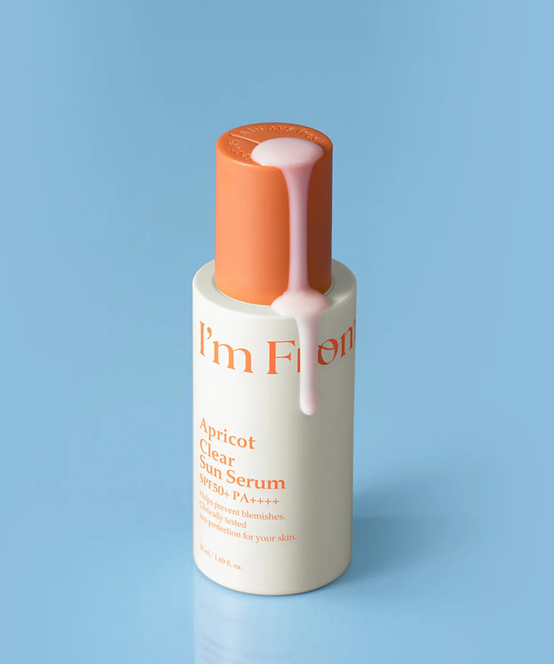 Le sérum solaire I'M FROM Apricot Clear Sun Serum 50ml posant sur une surface bleue, conçu pour protéger et hydrater votre peau.