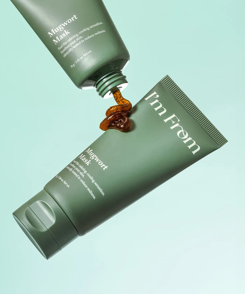 I'M FROM Mugwort Mask 70g dévoile sa texture, tube en cours d'utilisation sur fond vert.