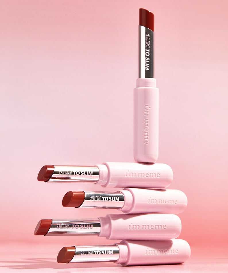 Rouges à lèvres IM MEME Slim to Slim Hyaluronic Gloss Fit Lipstick sur fond rose avec packaging élégant, hydratant.