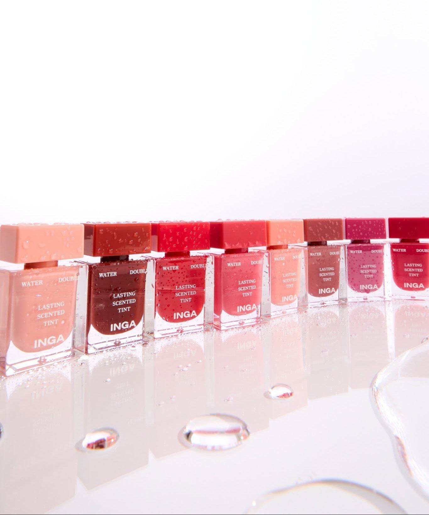 INGA Water Double Lasting Scented Tint 4.3g, marque INGA, produits colorés sur présentoir en vitrine, fond clair.