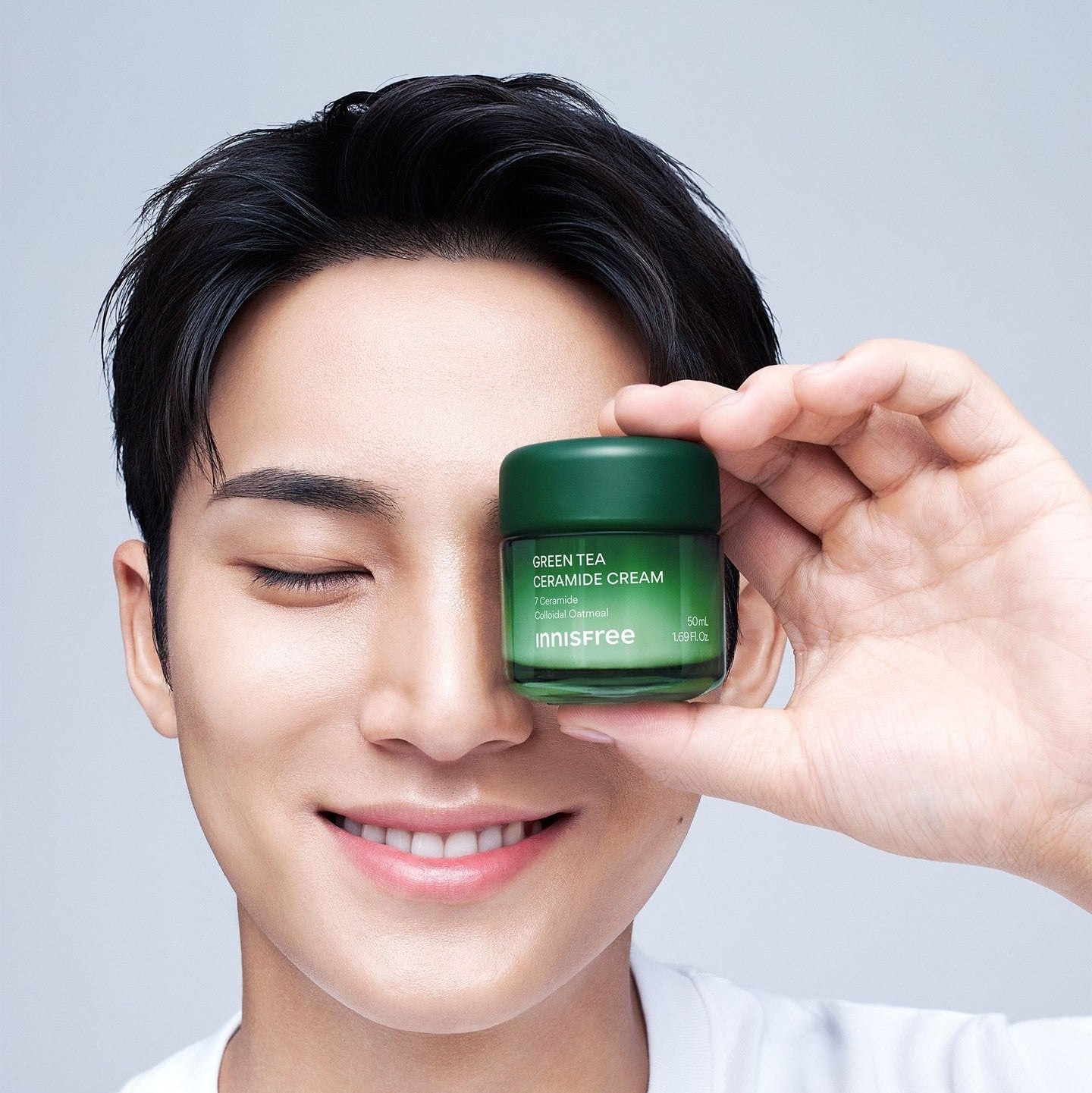 INNISFREE Green Tea Ceramide Cream 50ml, jeune homme tenant le pot vert sur fond clair, marque INNISFREE, crème visage