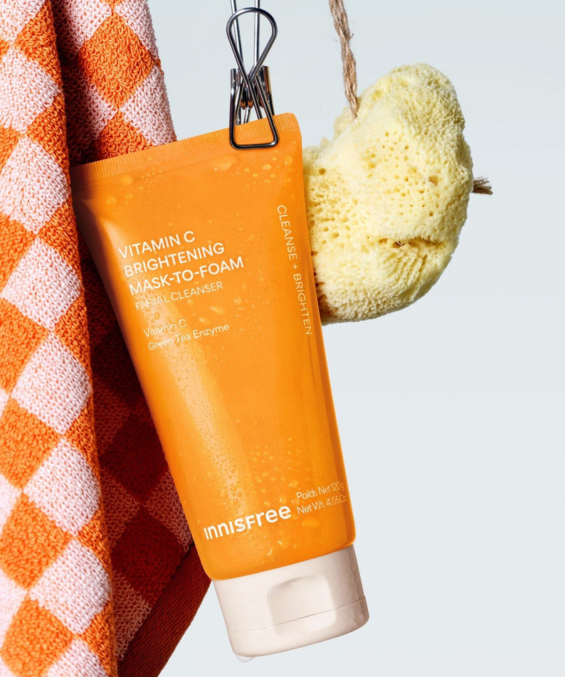 INNISFREE Vitamin C Brightening Pack-to-Foam 120g de la marque Innisfree, sur serviette orange et éponge, contexte salle de bain.