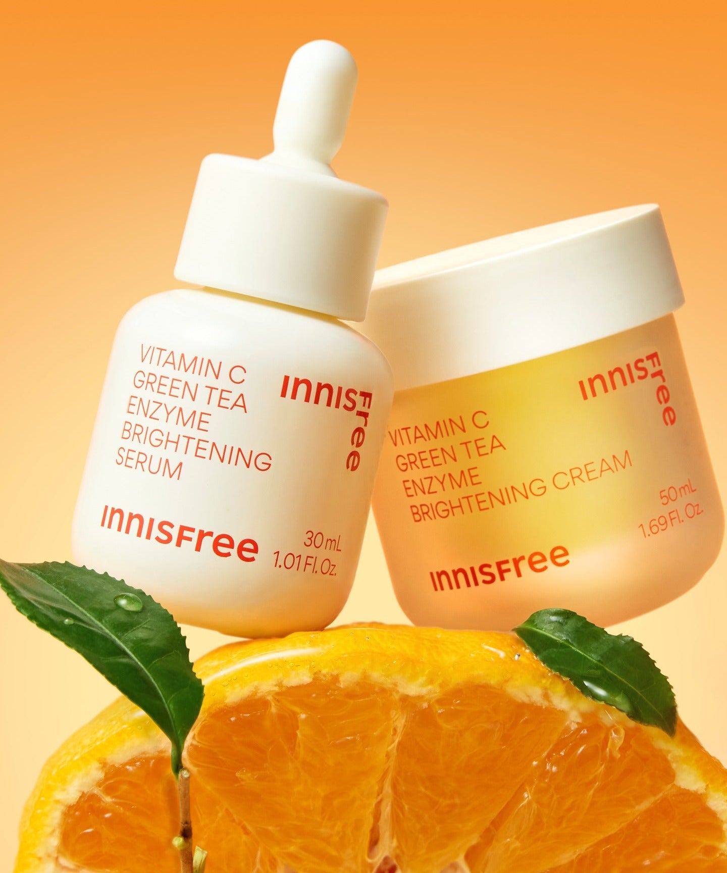 INNISFREE Vitamin C Enzyme Brightening Cream 50ml, pot sur fond orange avec feuilles et agrume, ambiance soin visage