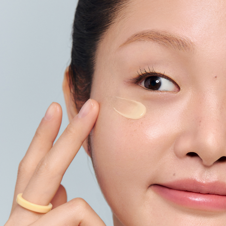 INNISFREE Vitamin C Niacinamide Brightening Eye Serum 10ml : application crème contour des yeux sur visage, en gros plan.