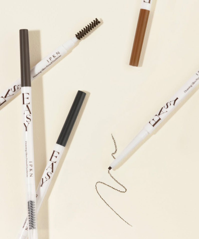 IPKN Easy Drawing Slim Pencil Eyebrow en différentes couleurs sur une surface crème, idéal pour des sourcils définis en toute simplicité.