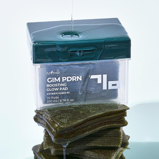 ISNTREE Kim PDRN Boosting Glow Pad 70 Sheets : boîtier bleu sur support, avec pads empilés, visuel produit beauté.