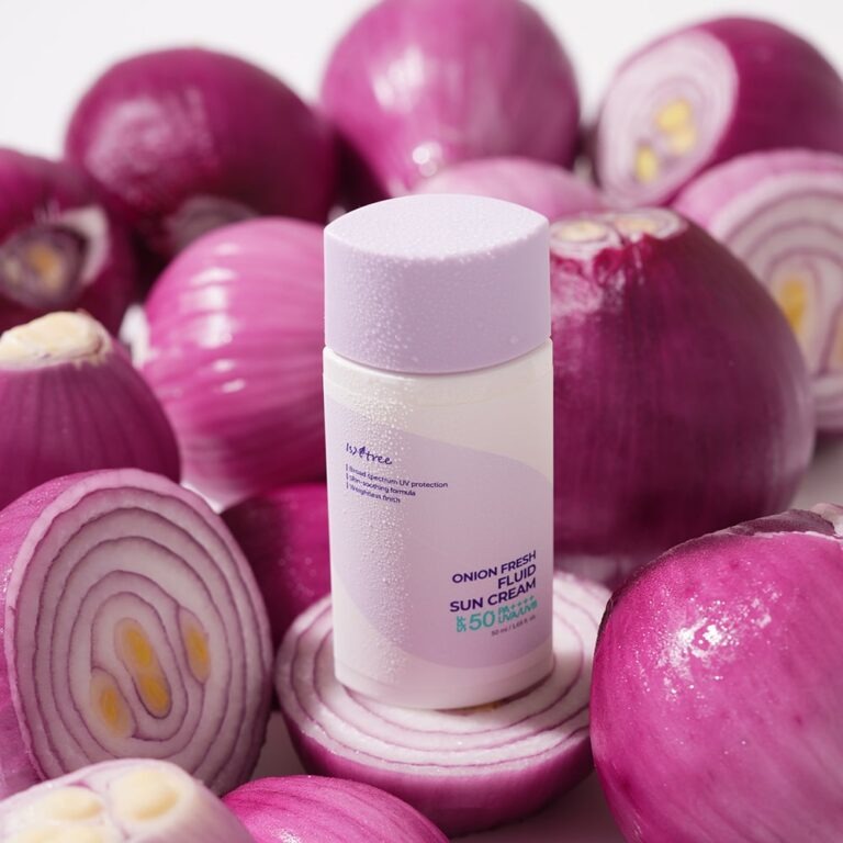 ISNTREE Onion fresh Fluid Sun Cream 50ml sur crème solaire, flacons et oignons rouges violets en arrière-plan.