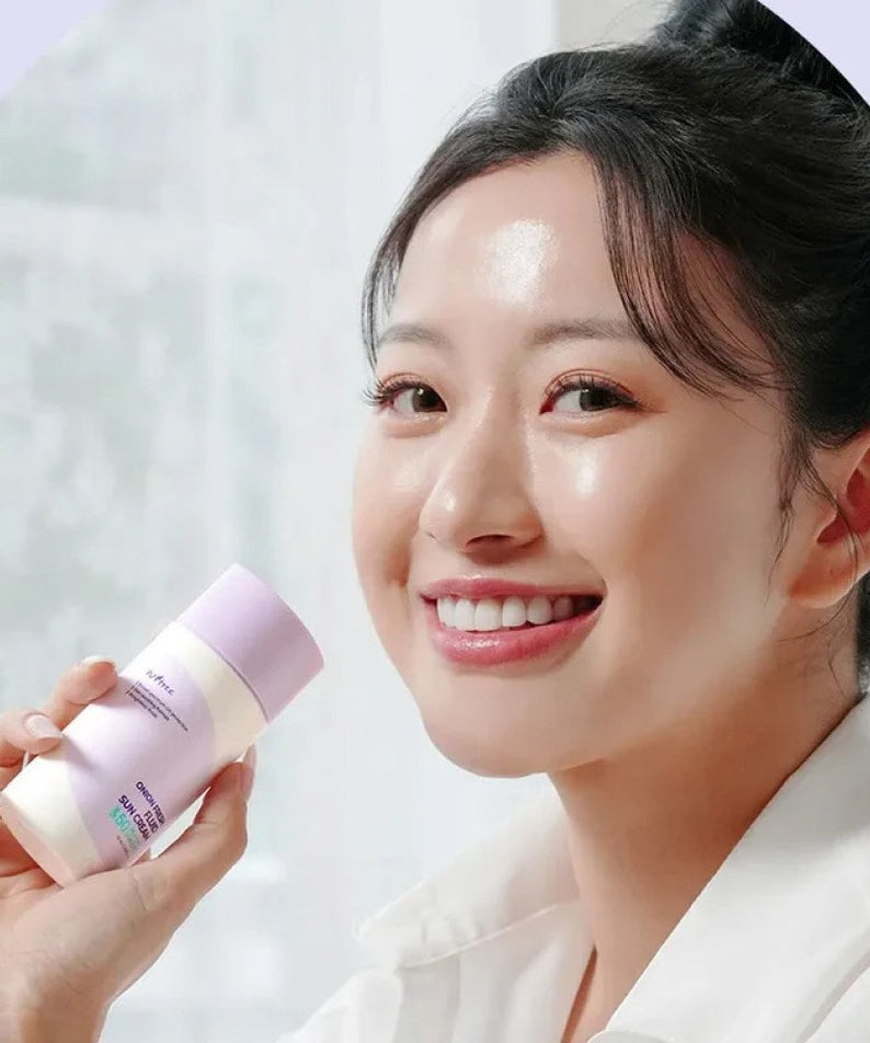 ISNTREE  Onion fresh Fluid Sun Cream 50ml : crème solaire fluide tenue sur une femme en laboratoire, flacon violet