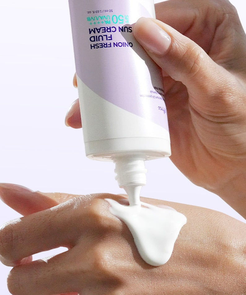 ISNTREE  Onion fresh Fluid Sun Cream 50ml, main appliquant une crème solaire sur la peau, visuel produit blanc