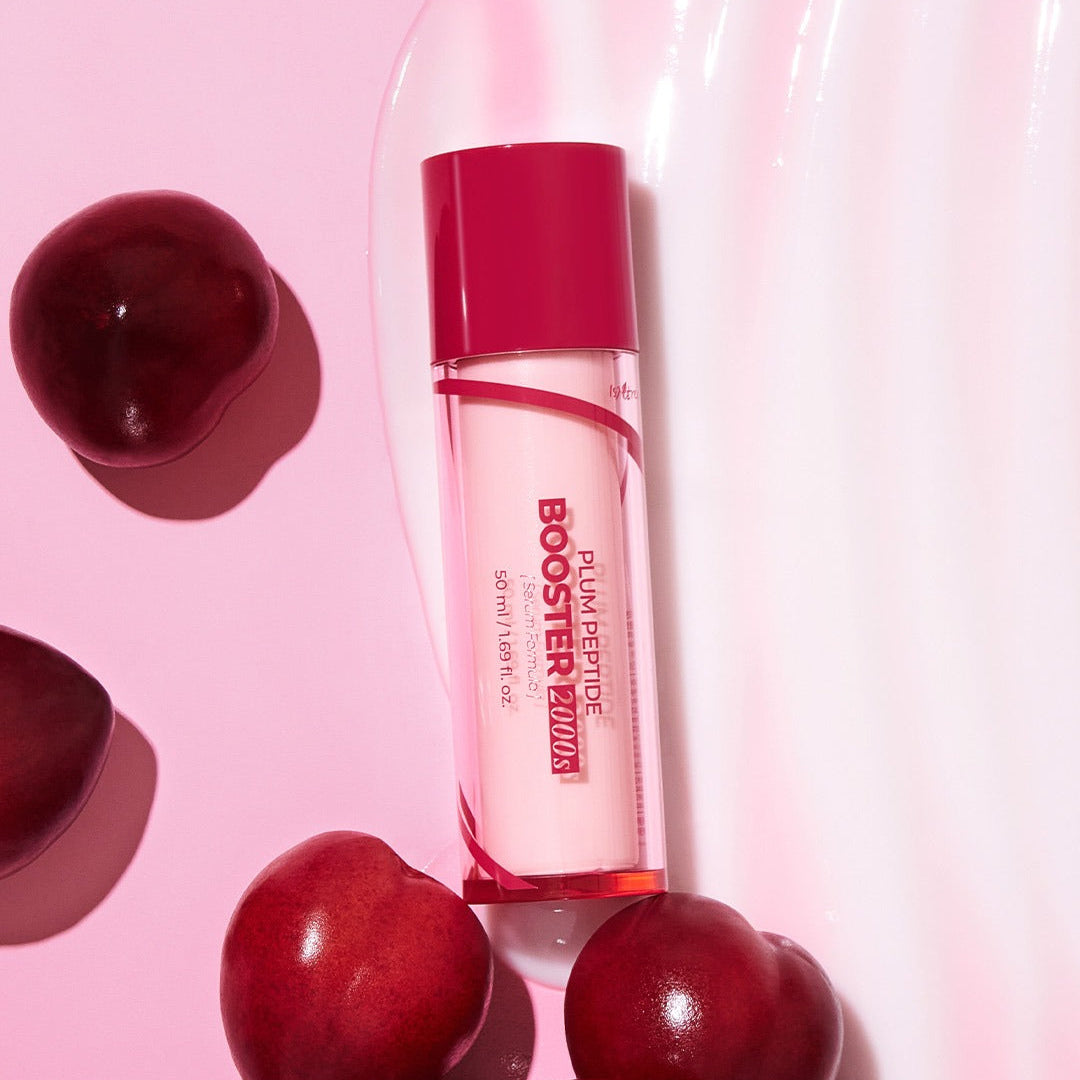 ISNTREE  Plum Peptide Booster 2000s 50ml, flacon rose avec bouchon rouge, entouré de prunes sur fond rose, photo produit
