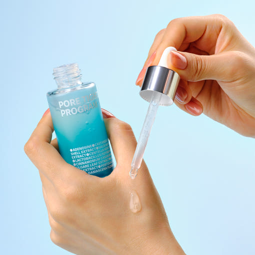 ISOI Pore Tightening Program (Pore Ampoule) 30ml, main tenant le sérum et la bouteille bleue ISOI sur fond bleu clair