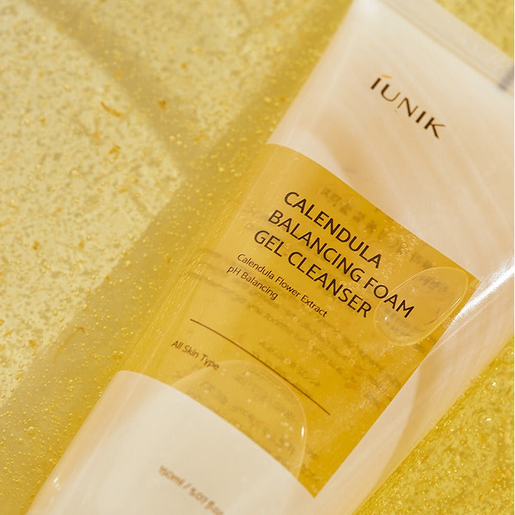 IUNIK Calendula Balancing Foam Gel Cleanser 150ml sur emballage jaune, contexte skincare beauté en gros plan.