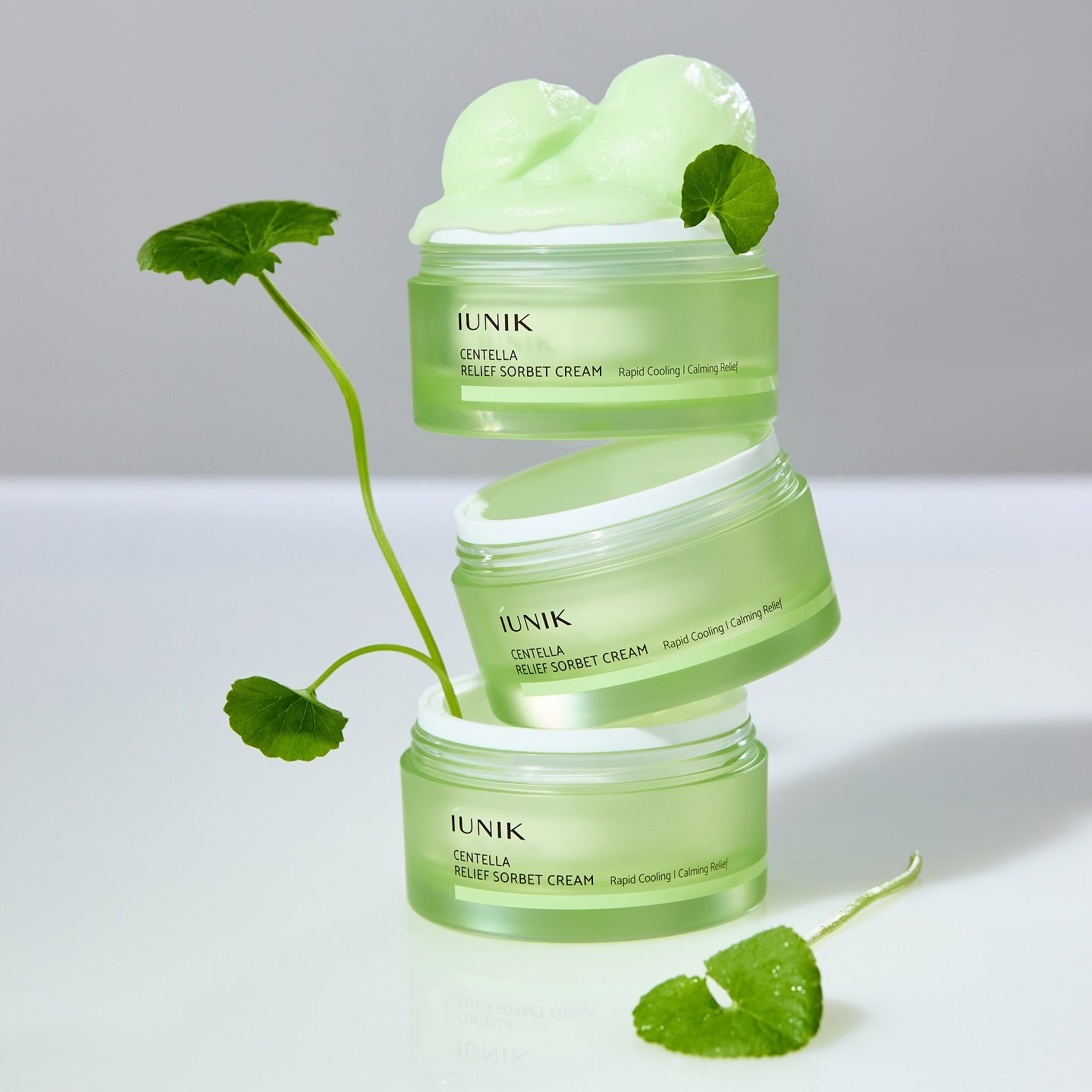 IUNIK Centella Relief Sorbet Cream 50ml : crème sorbet à la centella, pots verts sur fond clair, feuilles de menthe décor.