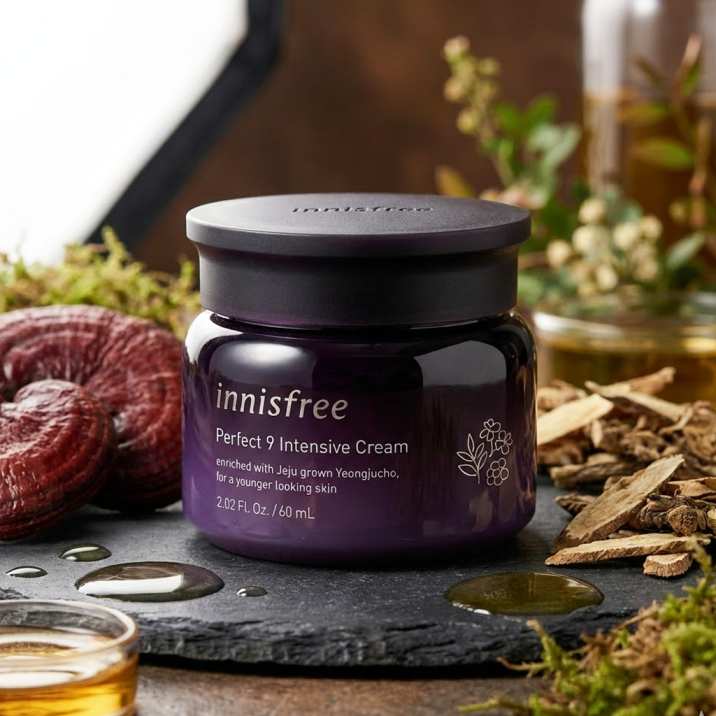 INNISFREE Perfect 9 Intensive Cream 60ml, pot sur pierre noire avec plantes et flacons, style naturel en arrière-plan.