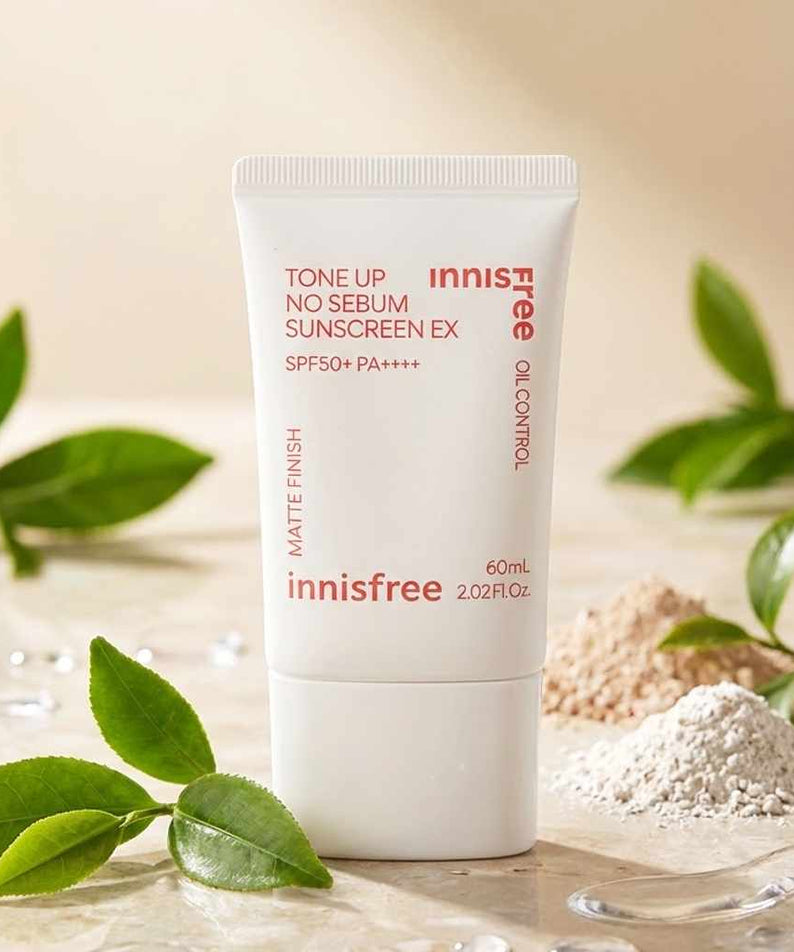 INNISFREE Tone Up No Sebum Sunscreen EX SPF 50+ PA++++ 60ml, tube blanc sur fond zen avec feuilles et poudre.