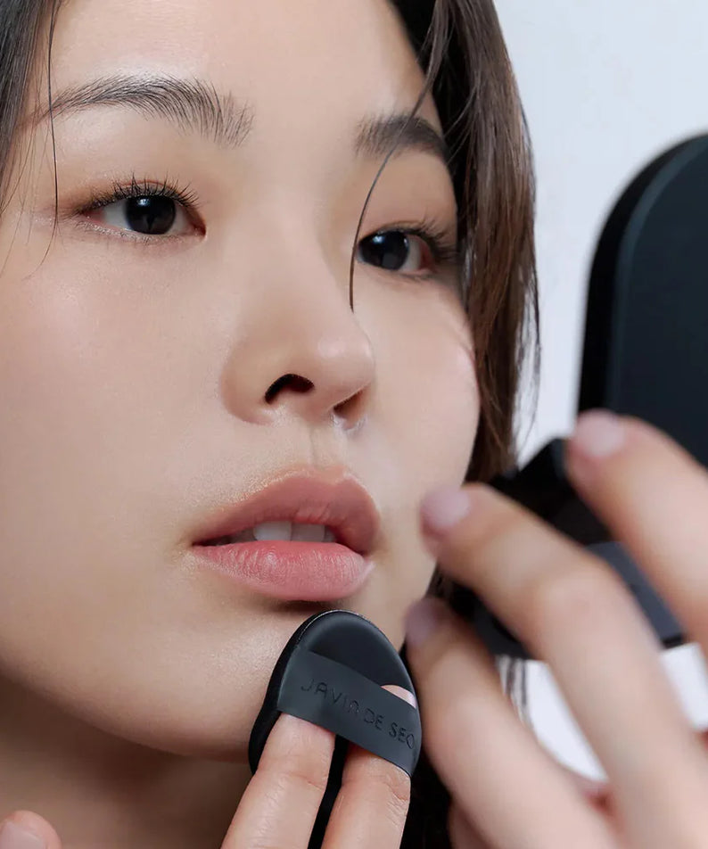 Femme appliquant le JAVIN DE SEOUL Wink Cushion Mat Pocket 8g avec miroir.