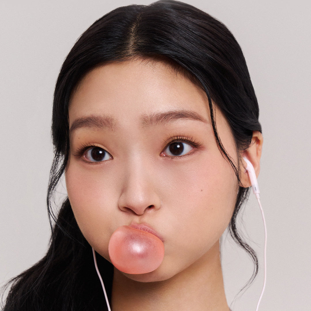 Décris l'image en français : JAVINDESEOUL Wink Cushion Shade Primer 8g, flacon maquillage sur fond clair, visage maquillé, marque visible.