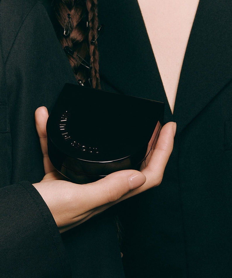 Boîte élégante de JAVIN DE SEOUL Wink Cushion Glow 16g tenue par une main, produit cosmétique de luxe