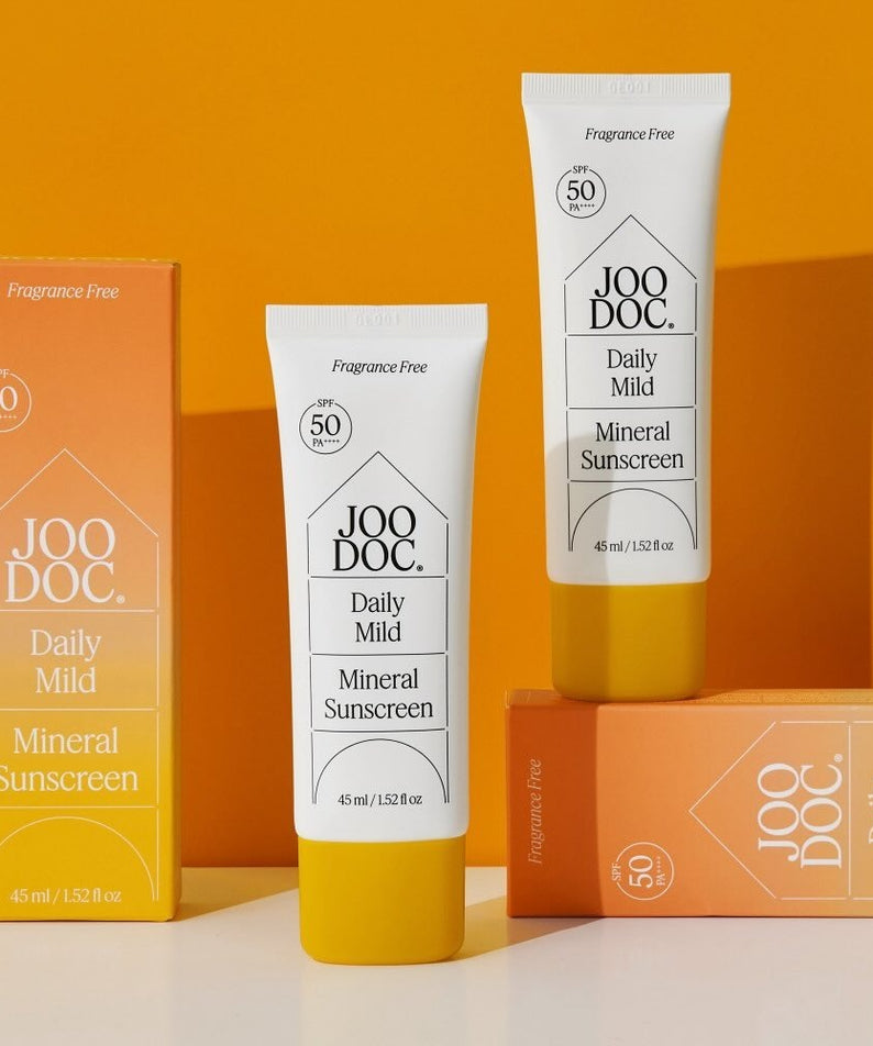 JOODOC  Daily Mild Mineral Sunscreen 45ml, tubes de crème solaire minérale sans parfum sur fond orange, marque JOODOC