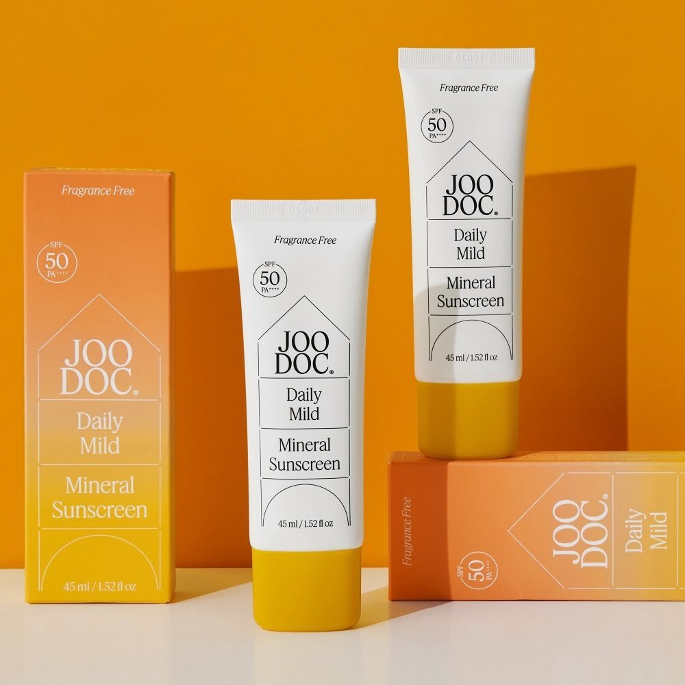 JOODOC  Daily Mild Mineral Sunscreen 45ml, tubes de crème solaire minérale sans parfum sur fond orange, marque JOODOC