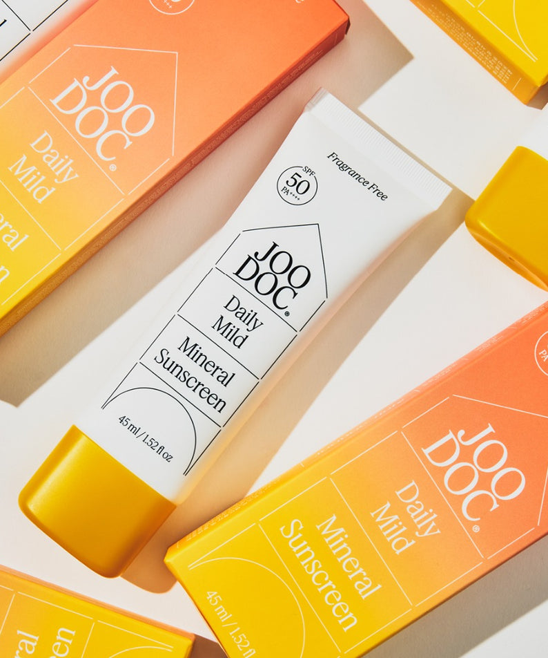 JOODOC  Daily Mild Mineral Sunscreen 45ml, vue produit en tubes, pack orange/jaune sur fond coloré en studio
