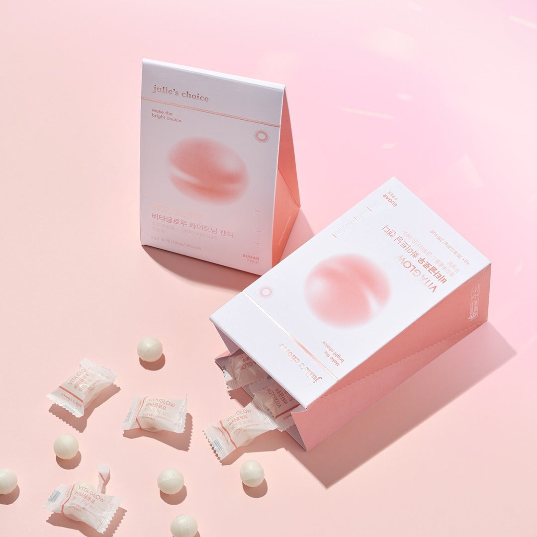 JULIE'S CHOICE Vita Glow Whitening Candy de la marque, photos produit sur fond rose pastel, bonbons éclaircissants visibles.
