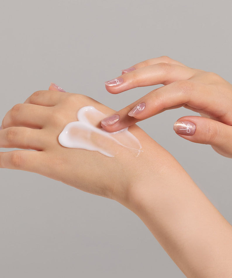 Application de JULYME Perfume Shea Butter Hand Cream 30ml sur les mains, montrant la texture de la crème hydratante.