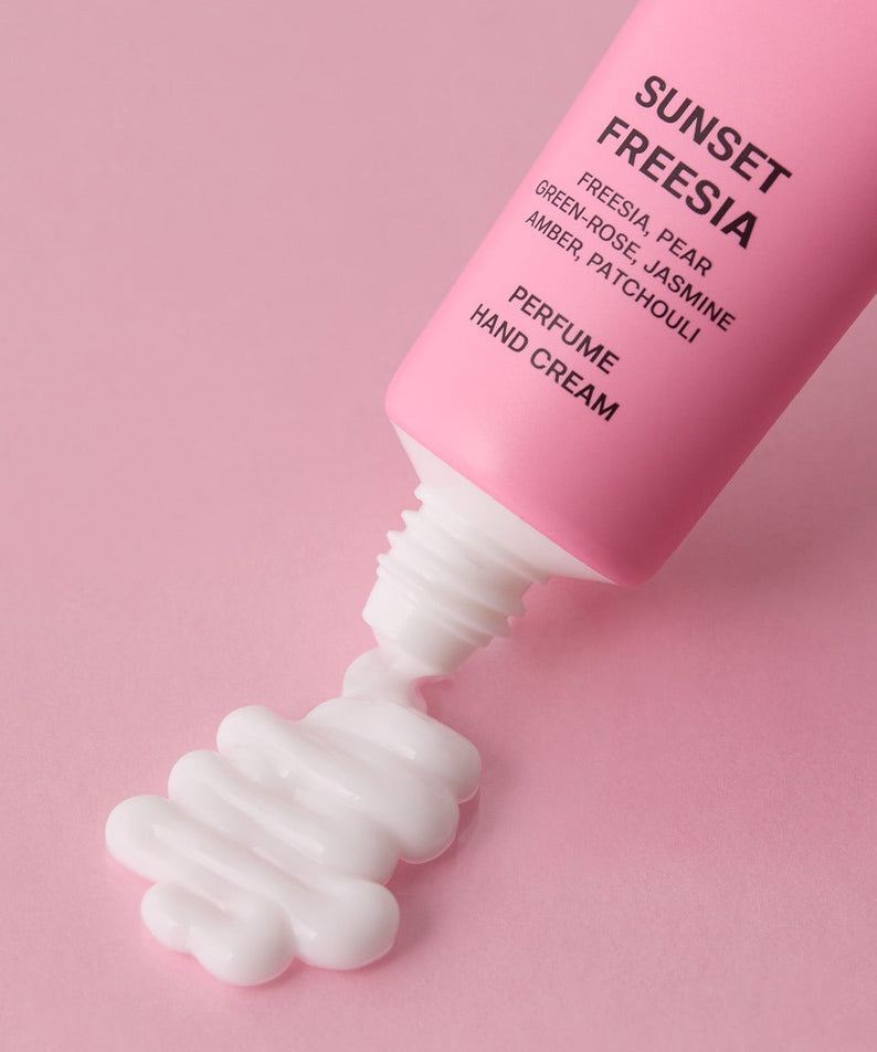 Crème pour les mains JULYME Perfume Shea Butter Hand Cream 30ml émanant un parfum délicat et nourrissant, posée sur un fond rose.