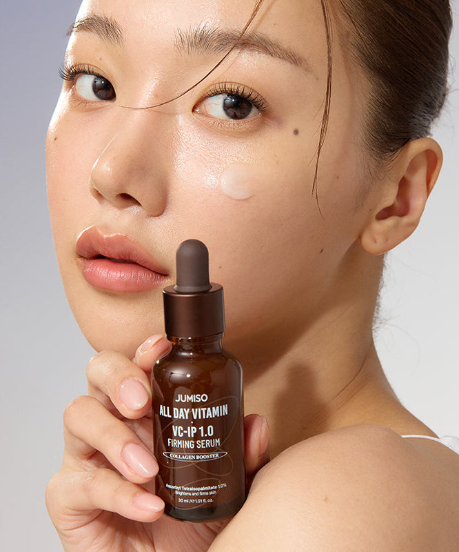 Femme tenant le sérum JUMISO All Day Vitamin VC-IP 1.0 Elasticity, peau éclatante et hydratée, améliore l'élasticité.