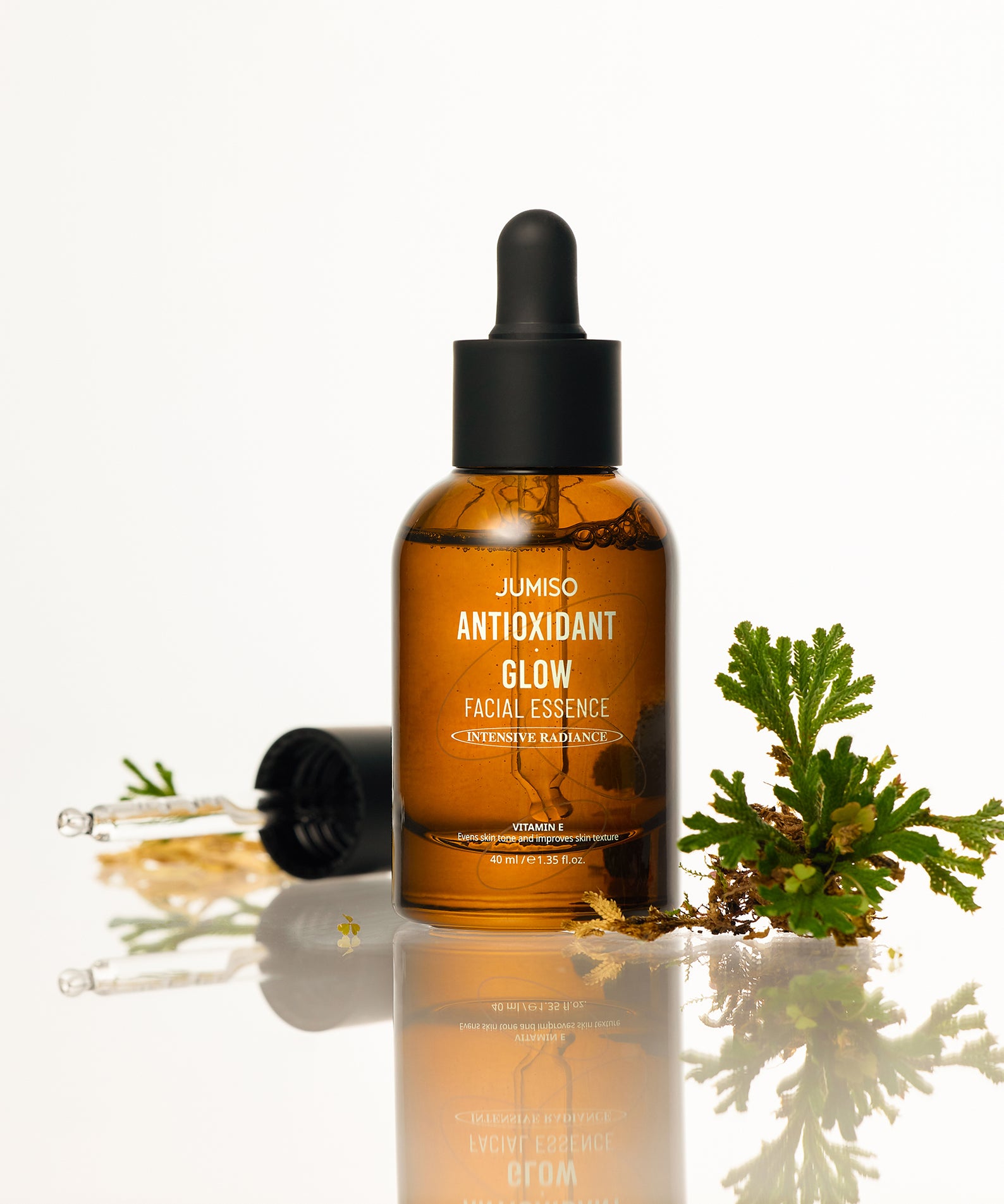 JUMISO Antioxidant Glow Facial Essence, élixir lumineux pour une peau éclatante, flacon et pipette sur fond blanc.