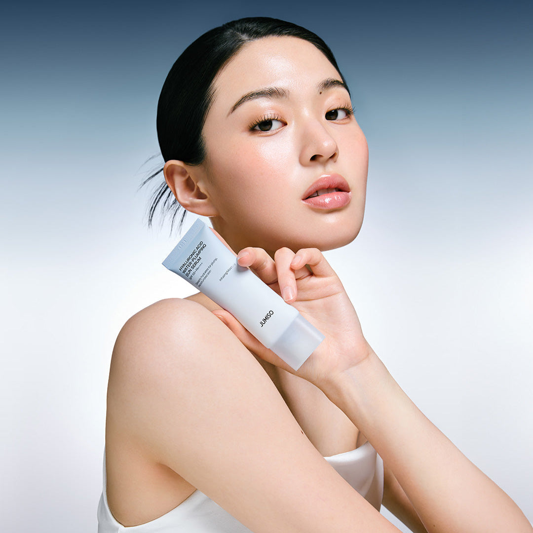 Photo produit : JUMISO Hyaluronic Acid Water Plumping Moisture Sun Serum 40ml, femme l’applique, fond bleu et blanc