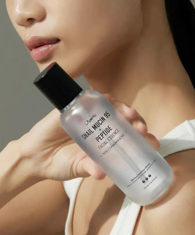 Flacon de JUMISO Snail Mucin 95+ Peptide Facial Essence 140ml tenu par une femme, produit de soin pour la peau en gros plan.